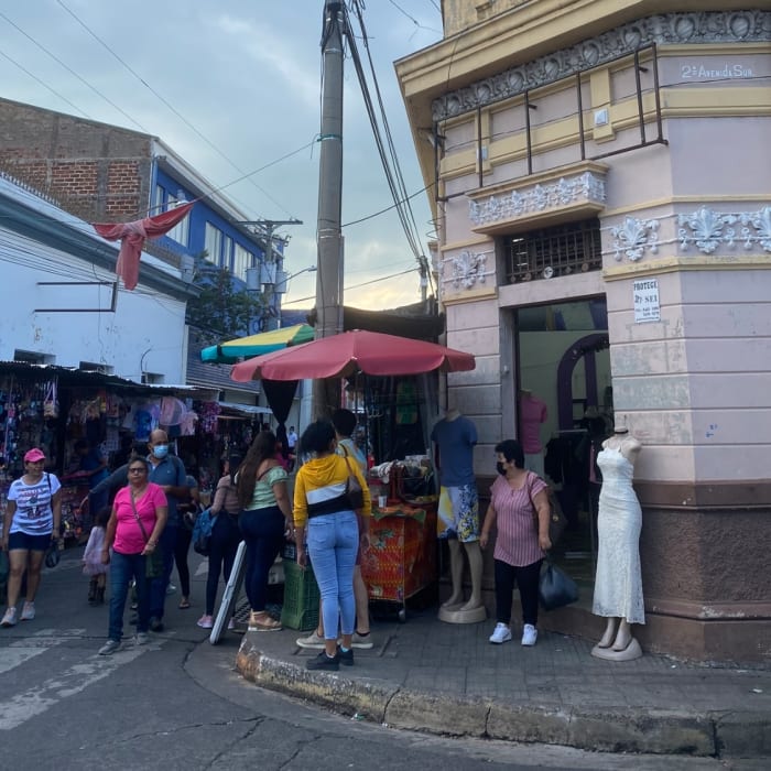 gente reunida en una calle comprando El Salvador